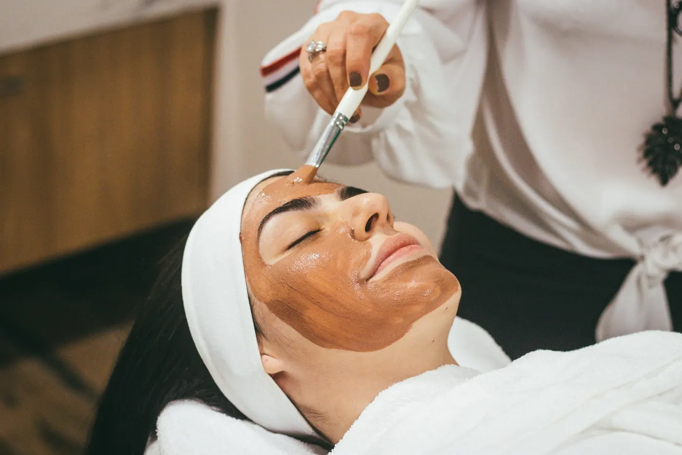 Facial treatment in a calm, light-filled LUMI treatment room